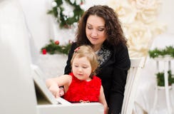 Moder och dotter som spelar på det vita pianot Royaltyfria Bilder Moder och dotter som spelar på det vita pianot Royaltyfria Bilder