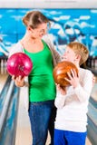Moder och son som spelar på bowlingmitten Arkivfoton Moder och son som spelar på bowlingmitten Arkivfoton