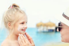 Moder som applicerar sunscreenskyddskräm på gullig liten litet barnpojkeframsida Mamma som använder sunblocking lotion för att sk arkivbilder Moder som applicerar sunscreenskyddskräm på gullig liten litet barnpojkeframsida Mamma som använder sunblocking lotion för att sk arkivbilder