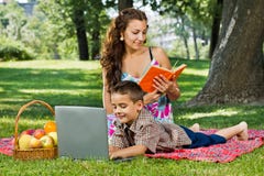 Moder som läser en bok i park arkivbilder Moder som läser en bok i park arkivbilder