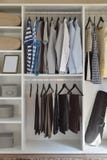 Modern closet with row of cloths hanging in white wardrobe stock image Modern closet with row of cloths hanging in white wardrobe stock image