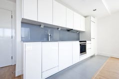 Modern fully fitted kitchen in white and gray royalty free stock photography Modern fully fitted kitchen in white and gray royalty free stock photography