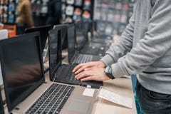 Modern male customer choosing laptop in the computer store Stock Photo Modern male customer choosing laptop in the computer store Stock Photo