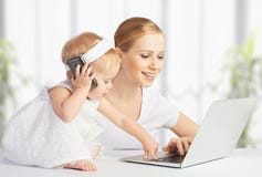 Modern med behandla som ett barn dotterarbeten med en dator och en telefon Arkivbilder Modern med behandla som ett barn dotterarbeten med en dator och en telefon Arkivbilder