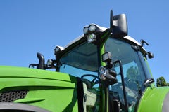 Modern traktorkabin Ny gr?n traktor med billyktor royaltyfria bilder Modern traktorkabin Ny gr?n traktor med billyktor royaltyfria bilder