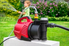 Modern water pump in garden on hot summer day Royalty Free Stock Photography Modern water pump in garden on hot summer day Royalty Free Stock Photography