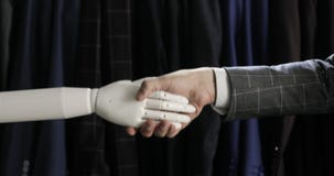 Moderne robotachtige technologieën Een mens communiceert met een robot, drukt een plastic mechanisch wapen aan de robot, handdruk stock video Moderne robotachtige technologieën Een mens communiceert met een robot, drukt een plastic mechanisch wapen aan de robot, handdruk stock video