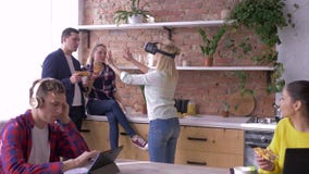 Moderne Technologie im Büro, junge Frau mit Sturzhelm der virtuellen Realität spielt Spiele, während Mitarbeiter wann essen und p stock footage Moderne Technologie im Büro, junge Frau mit Sturzhelm der virtuellen Realität spielt Spiele, während Mitarbeiter wann essen und p stock footage