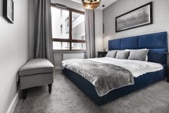 Modernes Schlafzimmer mit blauem Bett lizenzfreies stockbild Modernes Schlafzimmer mit blauem Bett lizenzfreies stockbild