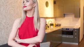 Modieuze elegante blondevrouw in huiswoonkamer, die rode sexy kleding dragen stock videobeelden Modieuze elegante blondevrouw in huiswoonkamer, die rode sexy kleding dragen stock videobeelden