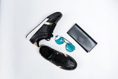 Modieuze tennisschoenen op een witte zool met zwarte sokken en gouden accenten, zonnebril met blauwe glazen en een zwarte beurs o royalty-vrije stock afbeelding Modieuze tennisschoenen op een witte zool met zwarte sokken en gouden accenten, zonnebril met blauwe glazen en een zwarte beurs o royalty-vrije stock afbeelding