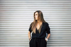Modna piękna kobieta ogląda lewica ponowna w czarnym kombinezonie obraz stock Modna piękna kobieta ogląda lewica ponowna w czarnym kombinezonie obraz stock