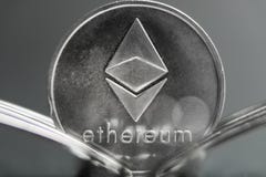 Moeda cryptocurreny de Ethereum colocada entre forquilhas com reflexão, forquilha dura foto de stock royalty free Moeda cryptocurreny de Ethereum colocada entre forquilhas com reflexão, forquilha dura foto de stock royalty free