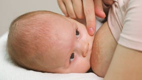 Moeder die een babymeisje de borst geven stock video Moeder die een babymeisje de borst geven stock video