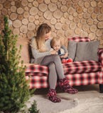 Moeder die een boek met babydochter lezen vóór Kerstmis royalty-vrije stock afbeelding Moeder die een boek met babydochter lezen vóór Kerstmis royalty-vrije stock afbeelding