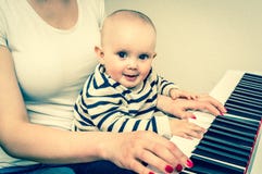 Moeder die haar leuke baby onderwijzen om piano te spelen - retro stijl stock foto's Moeder die haar leuke baby onderwijzen om piano te spelen - retro stijl stock foto's