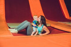 Moeder en haar zoon die op een trampoline in geschiktheidspark springen en exersice binnen doen royalty-vrije stock afbeeldingen Moeder en haar zoon die op een trampoline in geschiktheidspark springen en exersice binnen doen royalty-vrije stock afbeeldingen