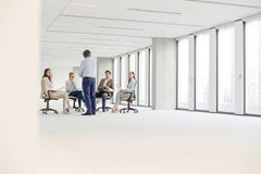 Mogen affärsman som har diskussion med kollegor som sitter på stol i nytt kontor arkivfoton Mogen affärsman som har diskussion med kollegor som sitter på stol i nytt kontor arkivfoton