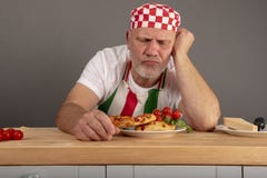 Mogen italiensk kock som ser ett mål som han har förberett arkivfoto Mogen italiensk kock som ser ett mål som han har förberett arkivfoto