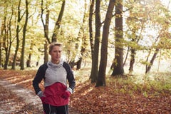 Mogen kvinnaspring till och med Autumn Woodland royaltyfri fotografi Mogen kvinnaspring till och med Autumn Woodland royaltyfri fotografi