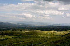 Moinho de vento branco, céu azul, nuvens brancas, montanhas verdes e águas imagens de stock Moinho de vento branco, céu azul, nuvens brancas, montanhas verdes e águas imagens de stock