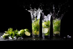 Mojito刷新在玻璃highball酒精饮料的夏天海滩热带鸡尾酒飞溅与苏打水,柠檬汁 免版税库存照片 Mojito刷新在玻璃highball酒精饮料的夏天海滩热带鸡尾酒飞溅与苏打水,柠檬汁 免版税库存照片