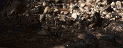 Molhe o córrego que corre através de rochas com as rochas no fundo foto de stock Molhe o córrego que corre através de rochas com as rochas no fundo foto de stock