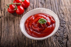 Molho da ketchup ou de tomate nos tomates brancos da bacia e de cereja na tabela de madeira imagens de stock royalty free Molho da ketchup ou de tomate nos tomates brancos da bacia e de cereja na tabela de madeira imagens de stock royalty free