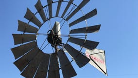 Molino de viento de Aermotor del vintage que hace girar en la brisa en una granja Molino de viento de Aermotor del vintage que hace girar en la brisa en una granja