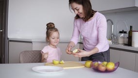 Mom και κόρες που μαγειρεύουν τα υγιή τρόφιμα στο σπίτι και που έχουν τη διασκέδαση Νέα γυναίκα που κόβει το κίτρινο μήλο στο γρα φιλμ μικρού μήκους Mom και κόρες που μαγειρεύουν τα υγιή τρόφιμα στο σπίτι και που έχουν τη διασκέδαση Νέα γυναίκα που κόβει το κίτρινο μήλο στο γρα φιλμ μικρού μήκους