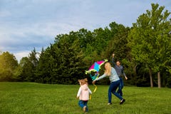 Mom, dad and child flying a kite. Happy family playing, smiling stock photos Mom, dad and child flying a kite. Happy family playing, smiling stock photos