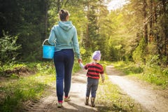 Mom and little daughter go on the road in the autumn forest. The family gather mushrooms and berries in the forest royalty free stock photos Mom and little daughter go on the road in the autumn forest. The family gather mushrooms and berries in the forest royalty free stock photos