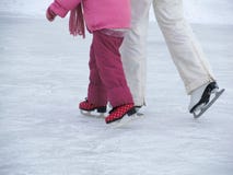 Mom teaches her little daughter to skate on the rink on a winter day. royalty free stock photos Mom teaches her little daughter to skate on the rink on a winter day. royalty free stock photos