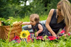 Mom και κοριτσάκι στη φύση που έχει το πικ-νίκ στοκ φωτογραφία Mom και κοριτσάκι στη φύση που έχει το πικ-νίκ στοκ φωτογραφία