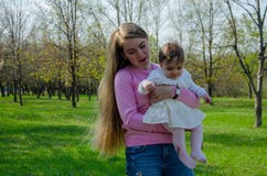 Mom με το μωρό στα φωτεινά ενδύματα σε ένα ρόδινο καρό στο πράσινο δικαίωμα Οικογένεια που στηρίζεται στο πάρκο σε μια θερμή ημέρ στοκ εικόνες με δικαίωμα ελεύθερης χρήσης Mom με το μωρό στα φωτεινά ενδύματα σε ένα ρόδινο καρό στο πράσινο δικαίωμα Οικογένεια που στηρίζεται στο πάρκο σε μια θερμή ημέρ στοκ εικόνες με δικαίωμα ελεύθερης χρήσης