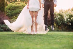 Momento fermato, un salto, salto nell'aria come se la sposa e lo sposo stiano volando sopra l'erba verde nel giardino, no immagini stock libere da diritti Momento fermato, un salto, salto nell'aria come se la sposa e lo sposo stiano volando sopra l'erba verde nel giardino, no immagini stock libere da diritti