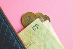 Monedas y billetes de banco de los países diferentes en cartera azul en fondo rosado imagenes de archivo Monedas y billetes de banco de los países diferentes en cartera azul en fondo rosado imagenes de archivo
