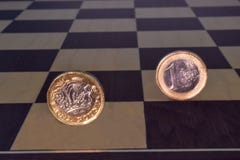 Monete dell'euro e della sterlina su una scacchiera fotografia stock libera da diritti Monete dell'euro e della sterlina su una scacchiera fotografia stock libera da diritti