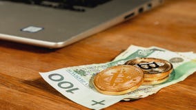 Monete simboliche dei bitcoins sopra le banconote polacche di zloty, computer portatile su fondo Contanti del bitcoin di scambio immagini stock libere da diritti Monete simboliche dei bitcoins sopra le banconote polacche di zloty, computer portatile su fondo Contanti del bitcoin di scambio immagini stock libere da diritti