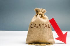 Money bag with the word Capital and arrow to down. Capital outflow. Currency devaluation. Falling stock quotes. Financial and stock photo Money bag with the word Capital and arrow to down. Capital outflow. Currency devaluation. Falling stock quotes. Financial and stock photo