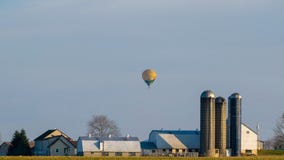 Mongolfiera che galleggia sopra una casa dell'azienda agricola di Amish, la contea di Lancaster, PA fotografie stock Mongolfiera che galleggia sopra una casa dell'azienda agricola di Amish, la contea di Lancaster, PA fotografie stock