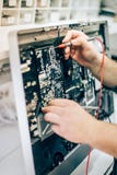 Moniteur défectueux d'ordinateur de réparation de technicien d'ingénieur d'électricien dans le service électrique photographie stock libre de droits Moniteur défectueux d'ordinateur de réparation de technicien d'ingénieur d'électricien dans le service électrique photographie stock libre de droits