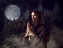 Monje medieval que ruega contra castillo y la Luna Llena fotografía de archivo libre de regalías Monje medieval que ruega contra castillo y la Luna Llena fotografía de archivo libre de regalías