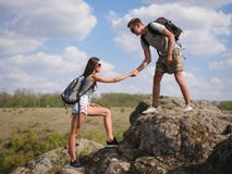 Montaña que sube de ayuda de la mujer del hombre joven Forma de vida sana imagenes de archivo Montaña que sube de ayuda de la mujer del hombre joven Forma de vida sana imagenes de archivo