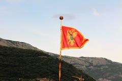 Montenegrinische Flagge über den Bergen gegen den Himmel stockfotografie Montenegrinische Flagge über den Bergen gegen den Himmel stockfotografie