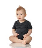 9 month infant child baby girl toddler sitting in dark grey shirt looking up isolated on a white Royalty Free Stock Image 9 month infant child baby girl toddler sitting in dark grey shirt looking up isolated on a white Royalty Free Stock Image