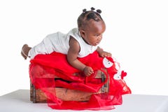 Toddler playing on a red crate. A 8 month old baby dressed to explore Christmas stock photo Toddler playing on a red crate. A 8 month old baby dressed to explore Christmas stock photo