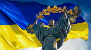 Monument of Independence of Ukraine in front of the Ukrainian flag. The monument is located in the center of Kiev on Independence