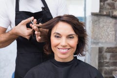 Mooi brunette die haar haarbesnoeiing krijgen stock fotografie Mooi brunette die haar haarbesnoeiing krijgen stock fotografie