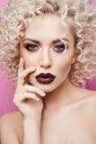 Mooi en modieus modelmeisje met verbazende blauwe ogen, met krullend blondehaar en met donkerrode die lippen worden geïsoleerd bi royalty-vrije stock afbeeldingen Mooi en modieus modelmeisje met verbazende blauwe ogen, met krullend blondehaar en met donkerrode die lippen worden geïsoleerd bi royalty-vrije stock afbeeldingen